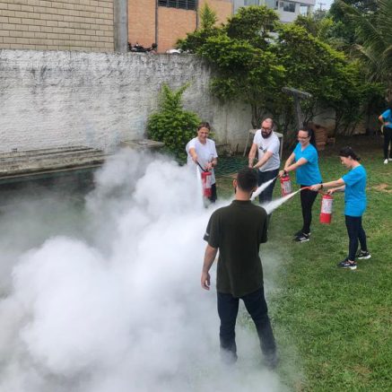 Colaboradores treinando uso de extintor em área externa